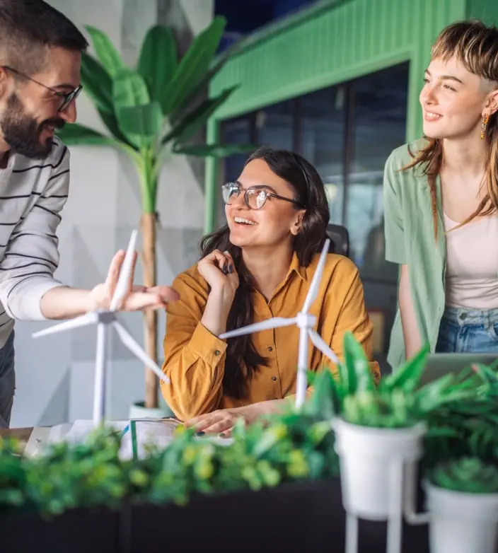 Three people in a greenhouse discussing corporate responsibility, green banking and corporate sustainability