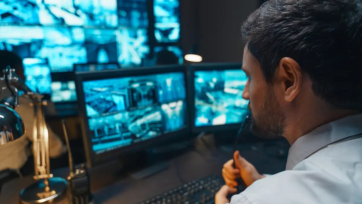 Man at computer analyzing risks and assessing prevention measures for ai and deepfake fraud.