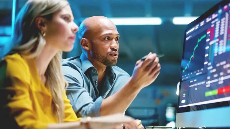 Business people, computer screen and finance graphs on screen.