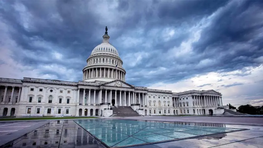 Exterior view of the U.S. Capitol building with dark clouds