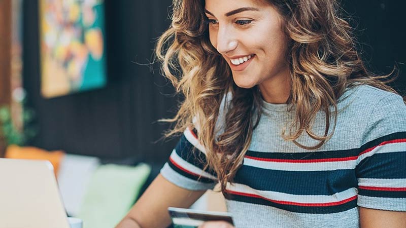 Woman making an online purchase through a platform that authenticates cardholder data to reduce payment fraud