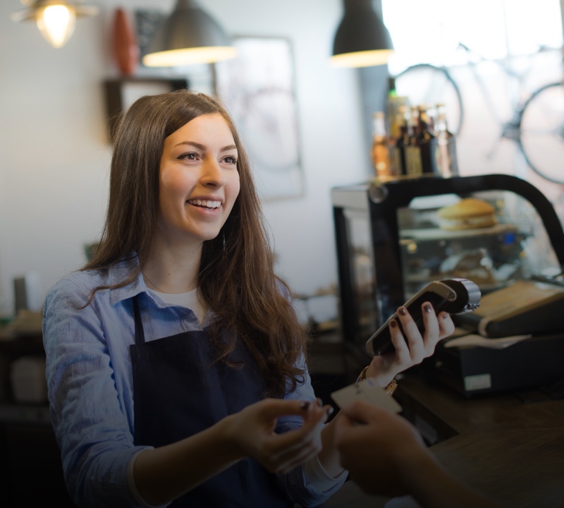 Young woman holding a handheld point of sale device