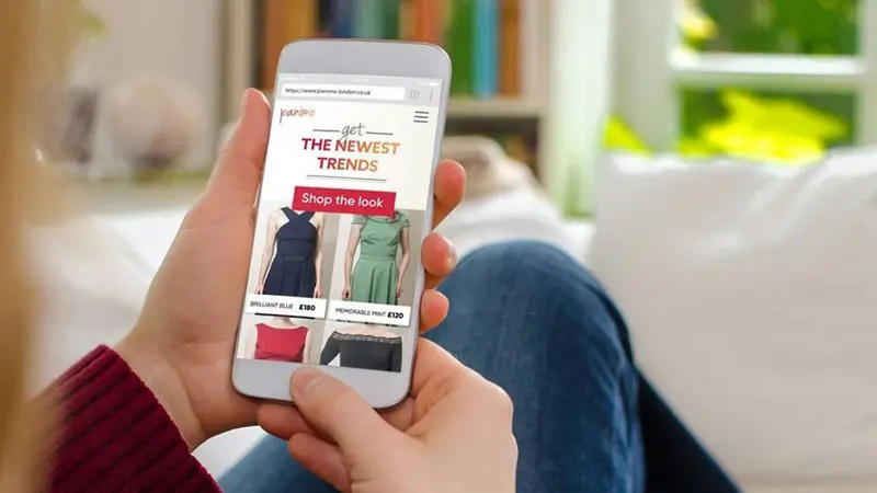 A person looking at phone swiping through the latest retail payment option trends.