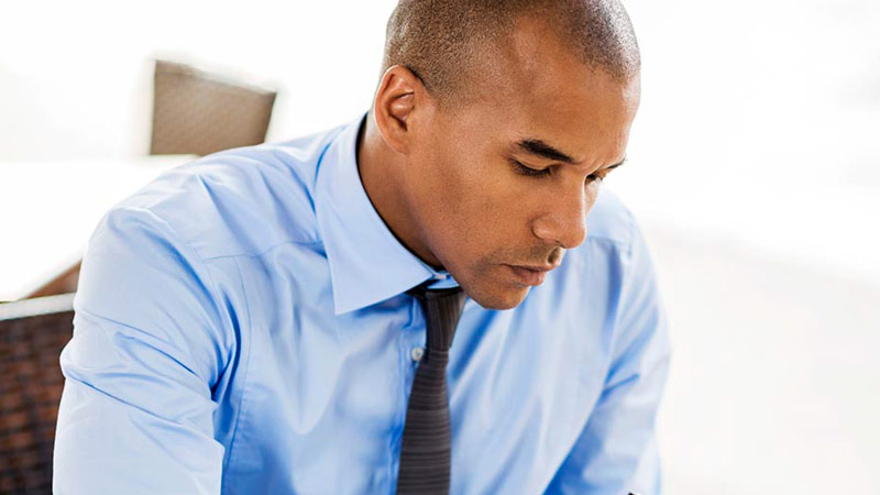 Office man looking down at device looking up what is the kyc rule and why it is important.