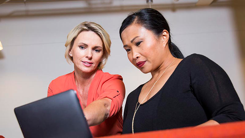 Two business women looking at a custody accounts on a laptop. 