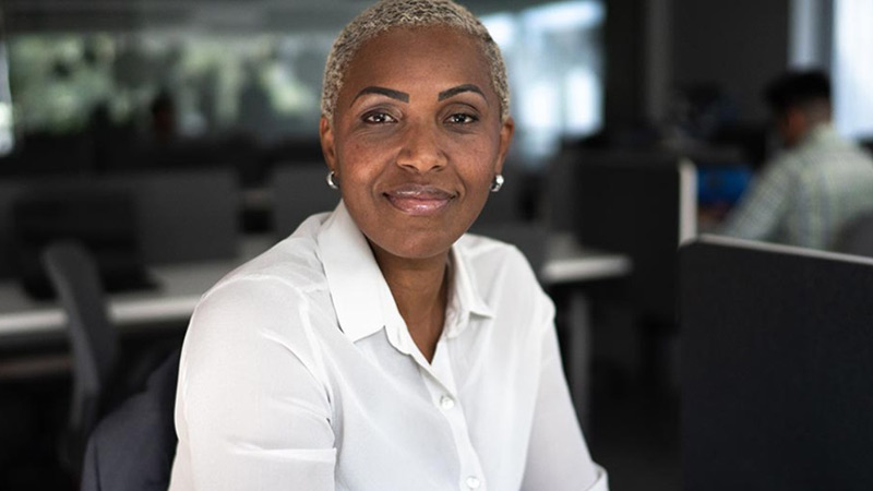 Professional woman sitting in an office chair, looking directly into the camera