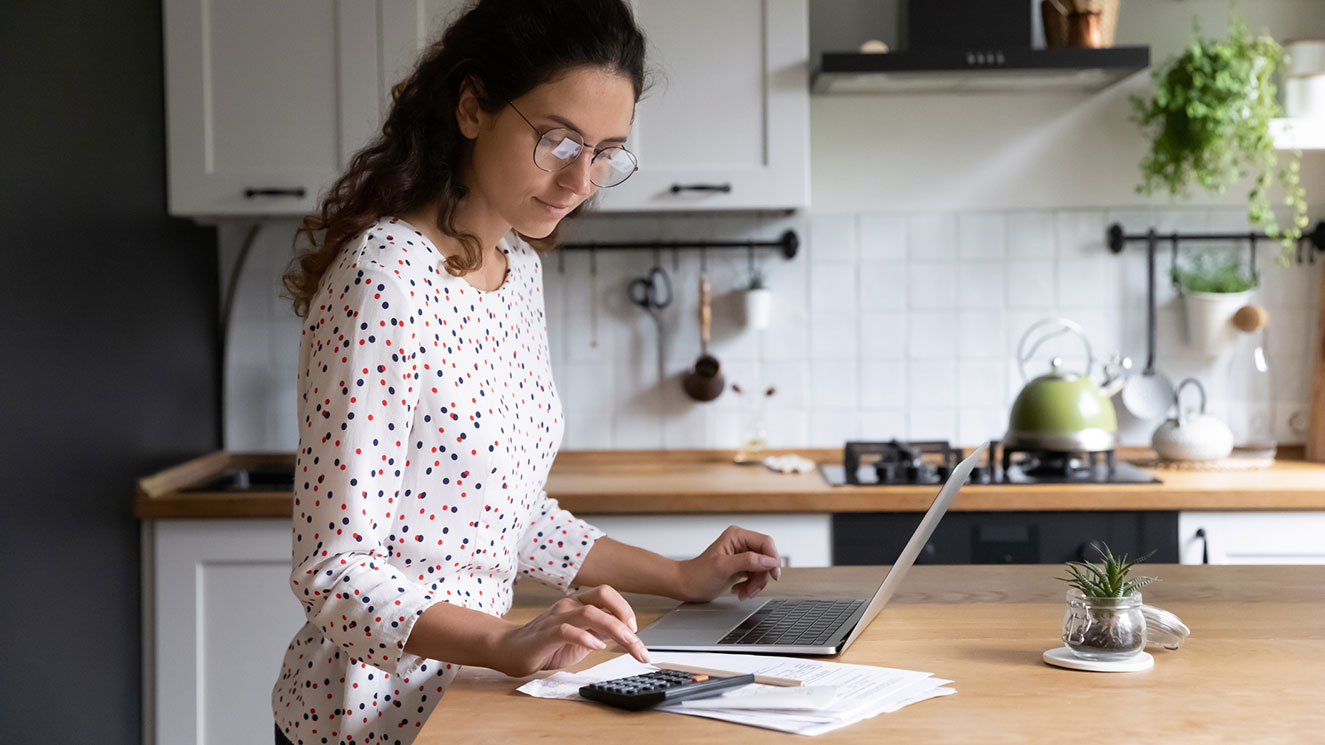 woman working on a laptop in her kitchen