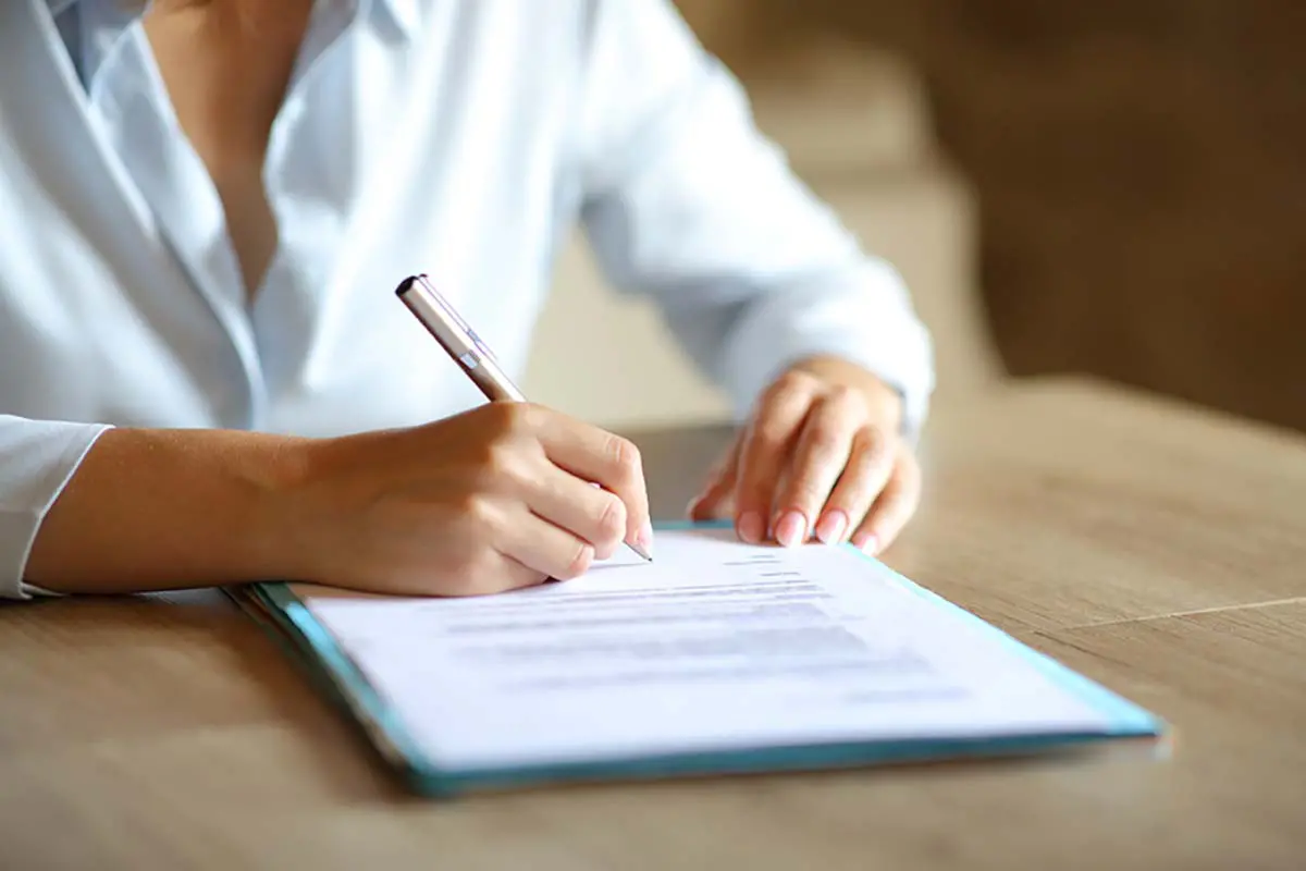close up of a woman writing on a piece of paper