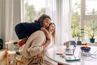 Mom and child at a table looking at laptop