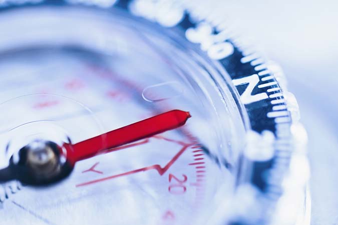 close up image of a compass with the needle pointing north