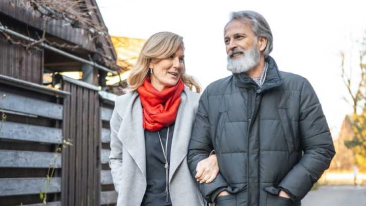 Retired couple walking and talking outside