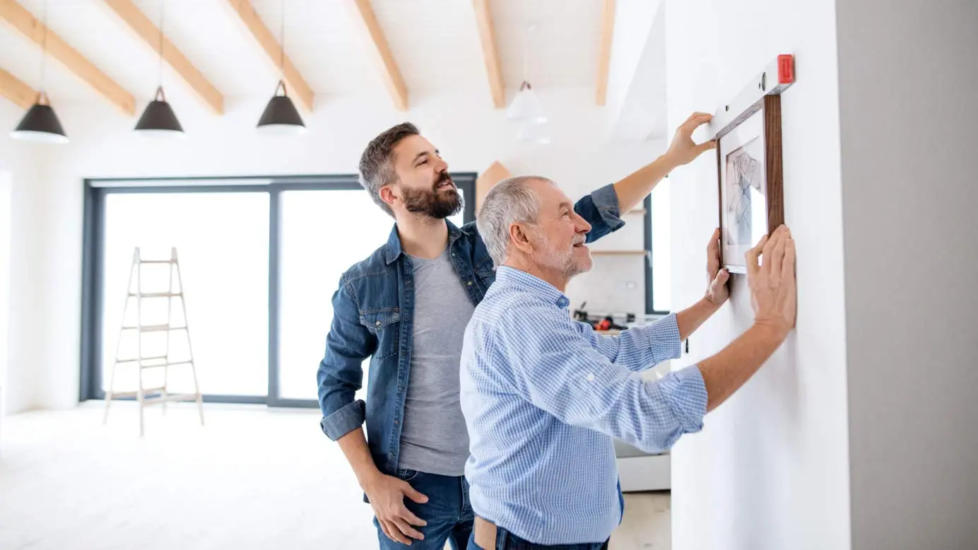 Father and son hanging a picture