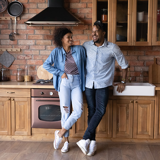 Una pareja sonriendo parada en la cocina remodelada