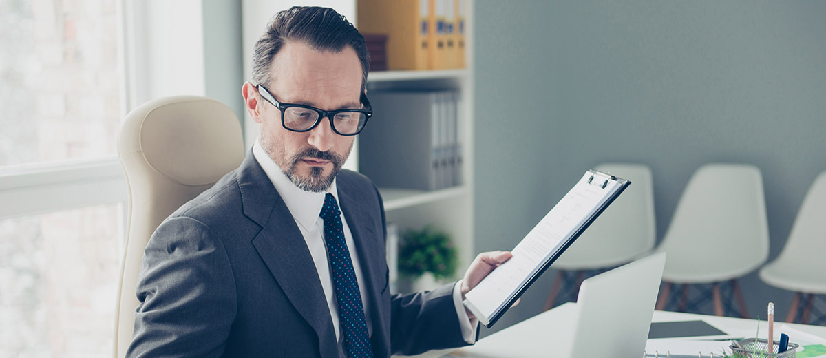 Man holding clipboard while working at desk