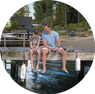 Father and daughter fishing from dock