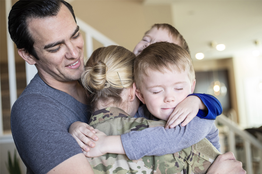 a military family hugging each other