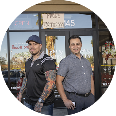Two men in front of their store