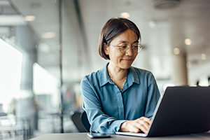 Asian woman working on a laptop in an office