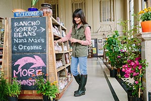 Woman smiling, looking around organic food store. 