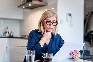 A woman looking at paperwork in her kitchen