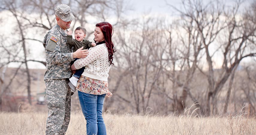 Young military family together in the woods. 