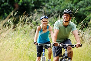 Man and woman riding bicycles in a field