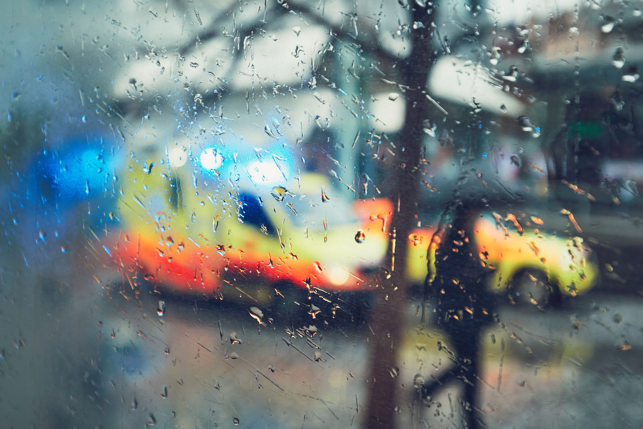 Emergency vehicles outside a rained on window