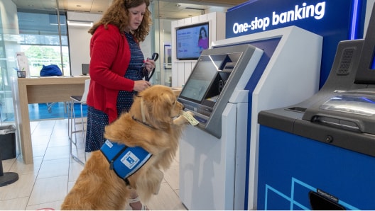 Service dog assists a U.S. Bank client with a withdrawal at a talking ATM.