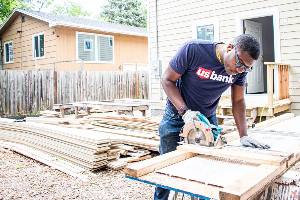 U.S. Bank employee works with a saw at a Habitat for Humanity event