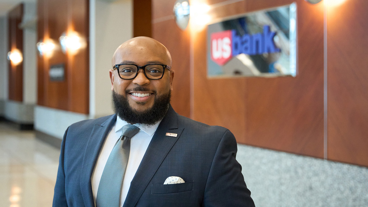 Marcus Brown standing in front of a wall with a U.S. Bank sign