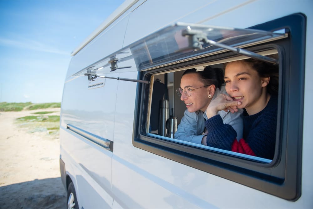 Woman and man looking out the window of their RV