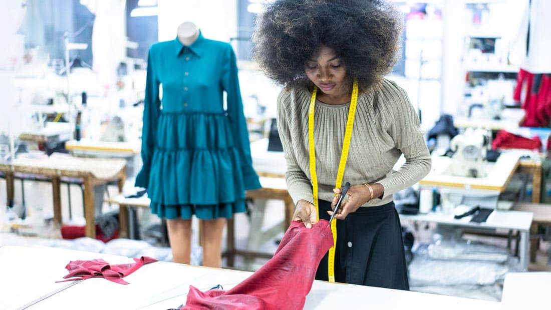 Fashion designer cutting fabric