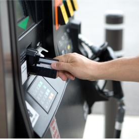 person inserting card at gas pump