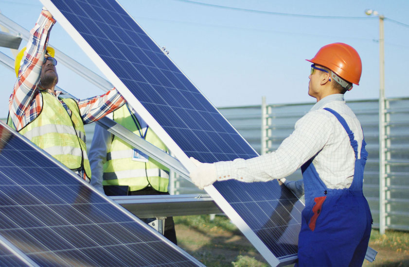 Two electrical workers installing solar panels