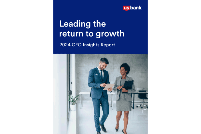 Two professionally dressed people walking down a hallway. The words “Leading the Return to Growth” are above them