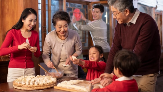 A family makes dumplings together in their home.